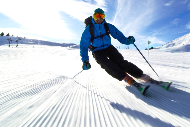 A man skiing at speed out in the snow.