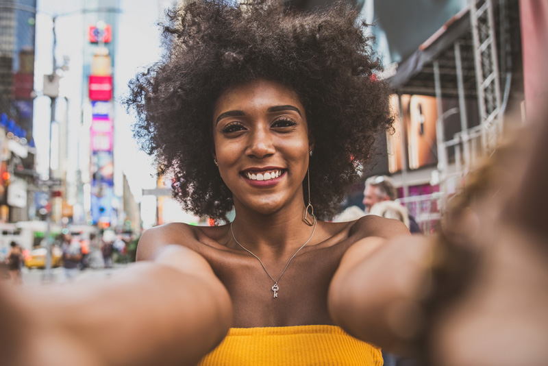 A young woman posing for a photo while exploring New York.